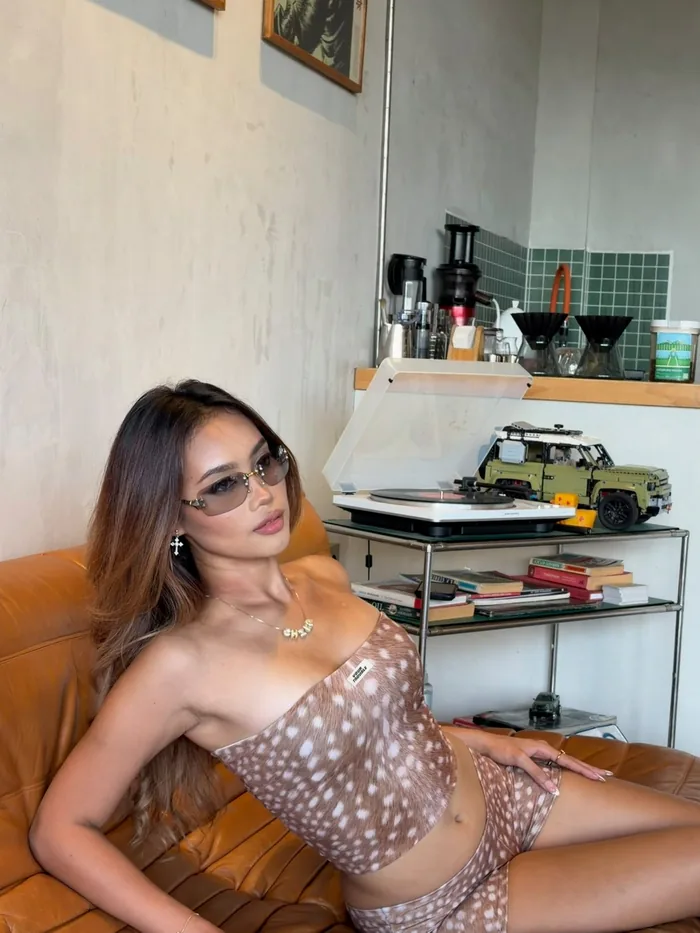 Chika memakai kacamata hitam di sofa kulit